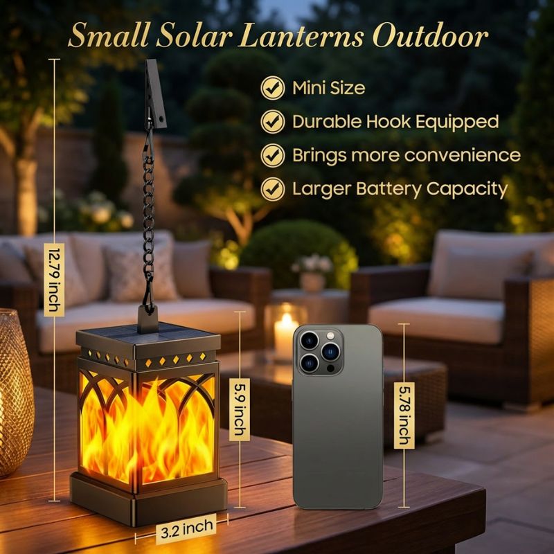 Small solar lantern outdoors with smartphone for scale, surrounded by outdoor furniture.