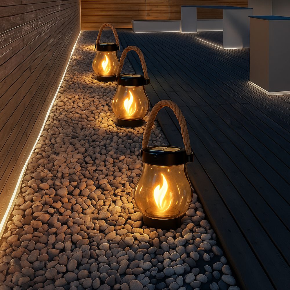 Solar-powered lanterns on pebbles near a wooden deck at night