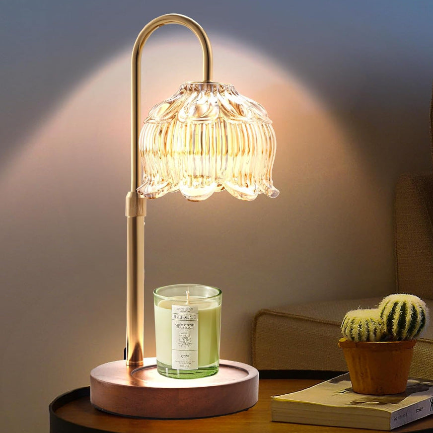 Decorative table lamp with a glass shade on a wooden surface, emitting a warm glow.