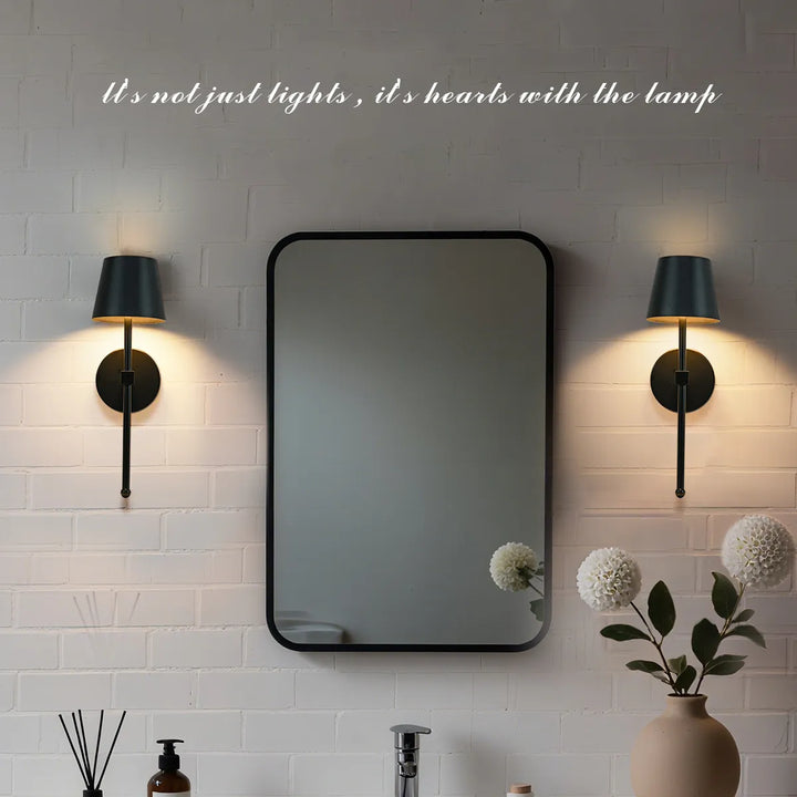 Bathroom setting with a mirror flanked by two wall lights on a tiled wall.