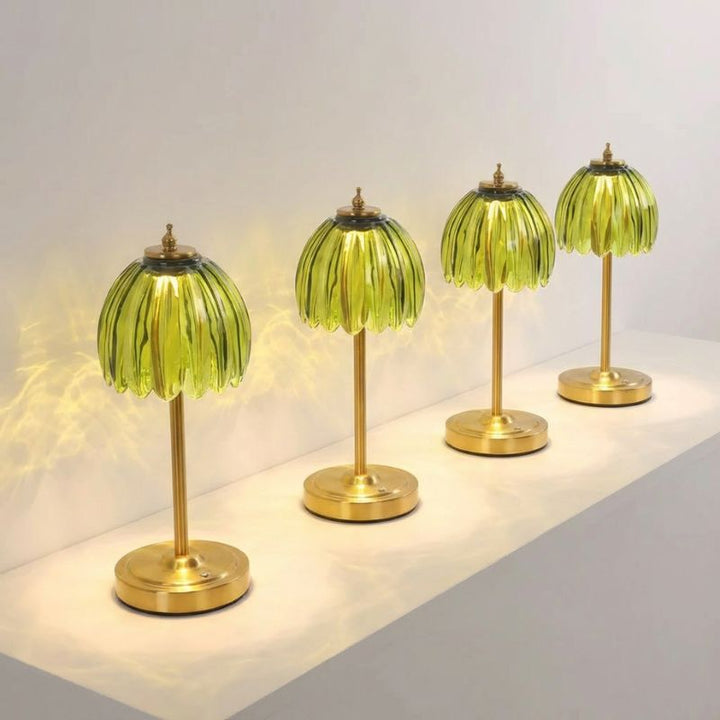 Green glass tulip lamp placed on a marble surface.
